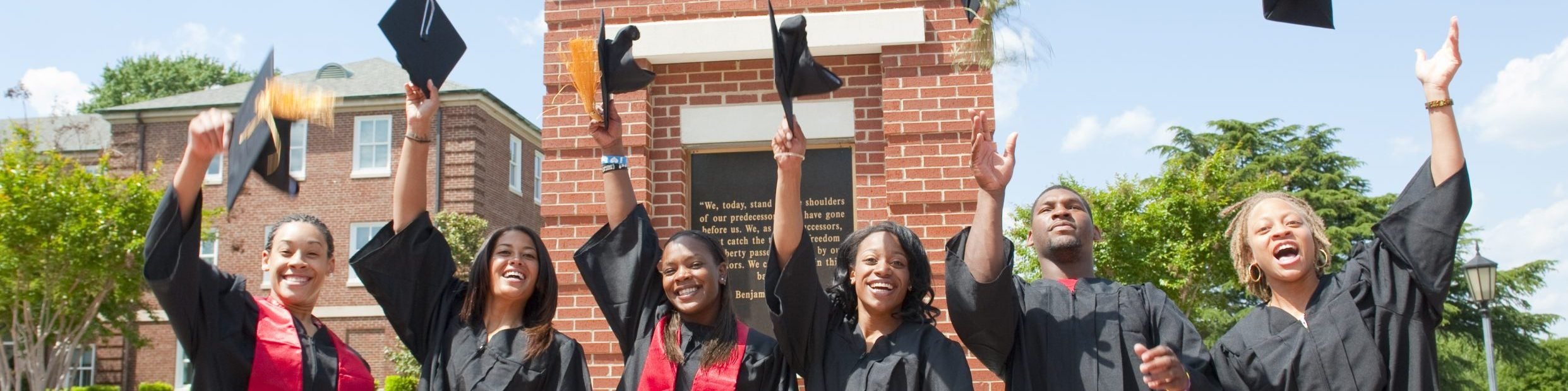 students throwing graduation caps in the air for celebration