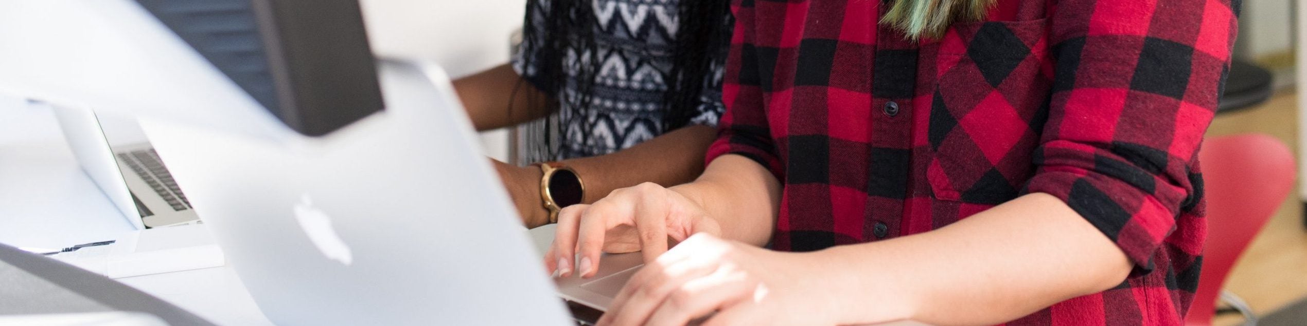 two women work together on computer